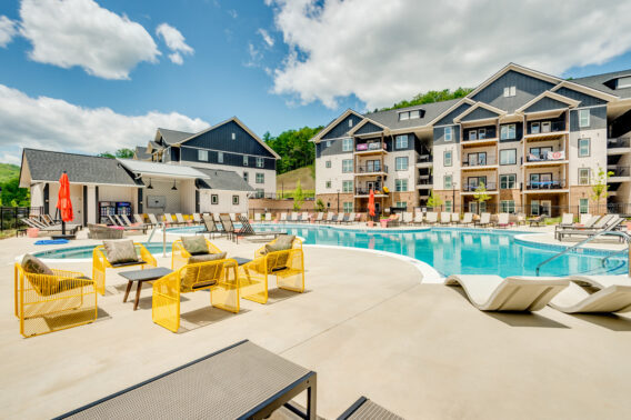 Resort style pool surrounded by yellow lounge chairs